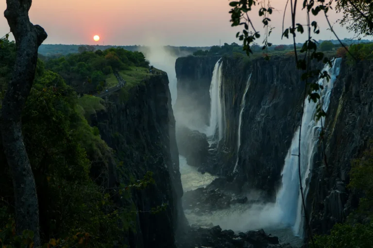 Victoria Falls cascading into a deep gorge at sunrise